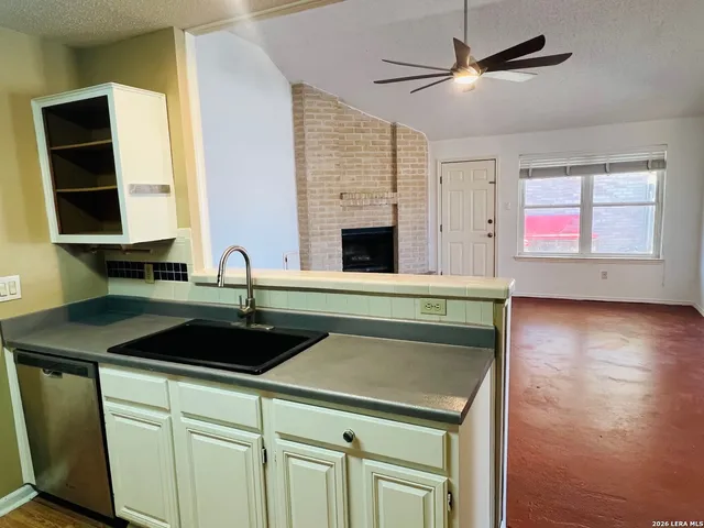 a kitchen with a sink cabinets and wooden floor