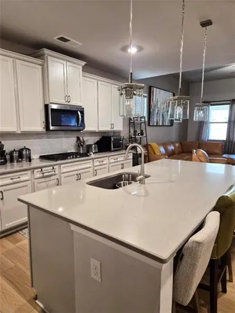 a kitchen with granite countertop white cabinets and stainless steel appliances
