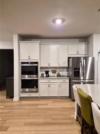 a kitchen with a table chairs microwave and cabinets