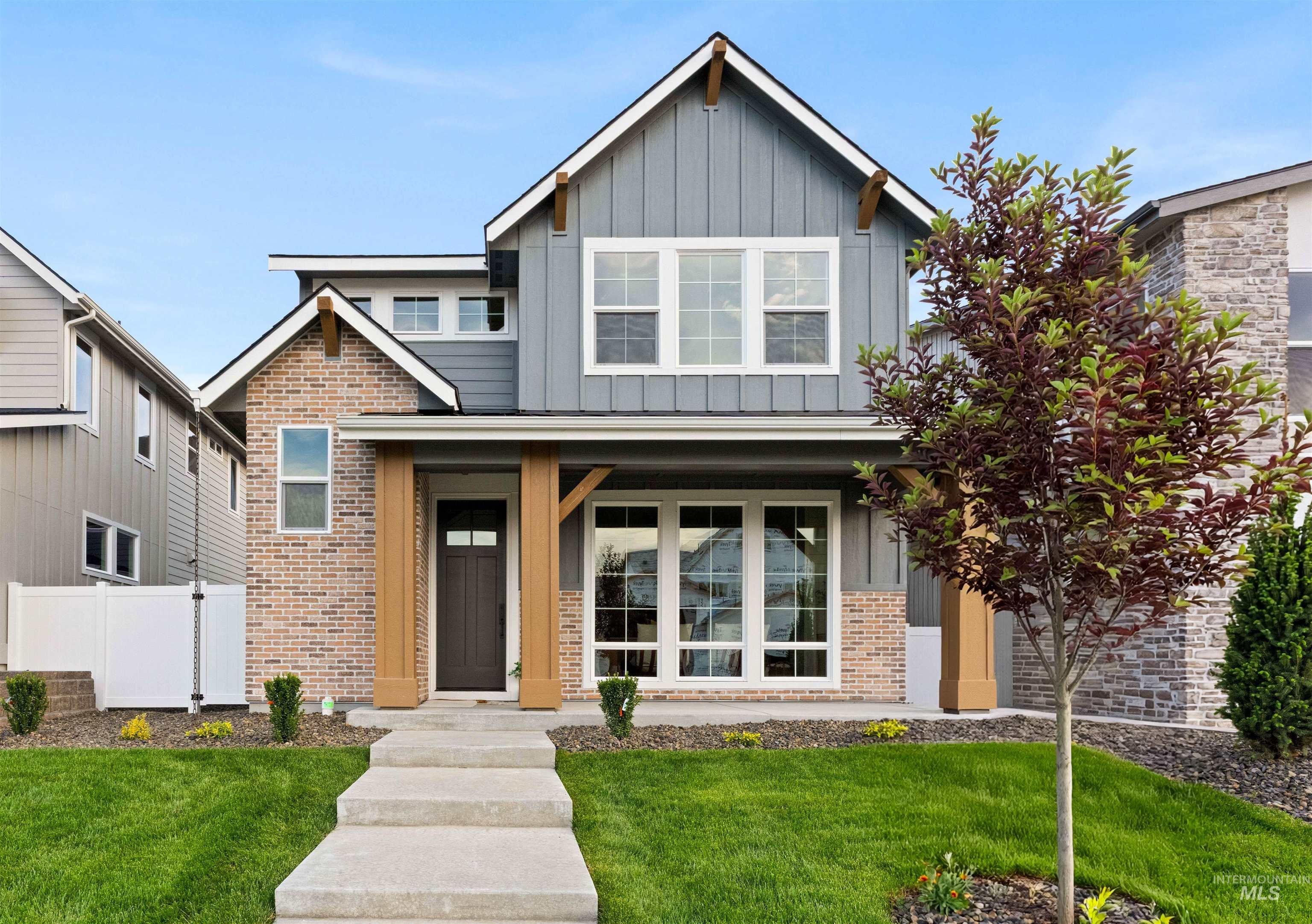 13338 North Spring Creek Way Boise, ID 83714 - Photo 1 of 46 Contemporary exterior featuring mixed-material siding, brick accents, and a covered porch with substantial wood-finish columns