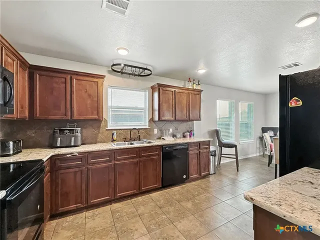 a kitchen with a sink a stove and cabinets