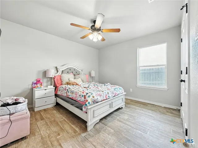 a bedroom with a bed chandelier and a window
