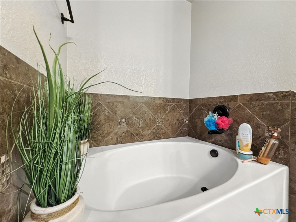 2701 Settlement Road Copperas Cove, TX 76522 - Photo 5 of 18 a bathroom with a bathtub and a potted plant