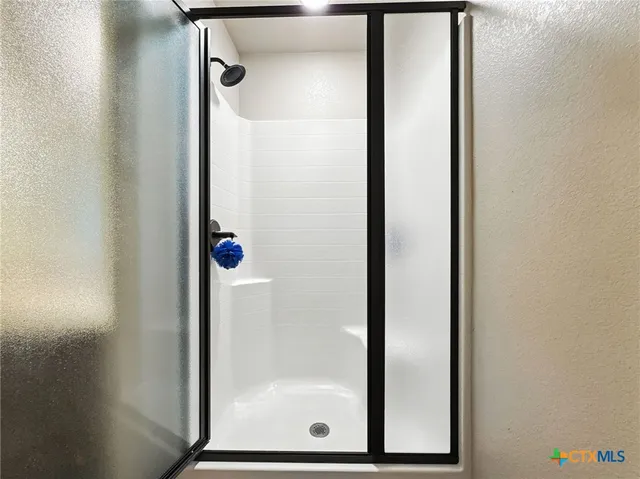 a bathroom with a glass shower door