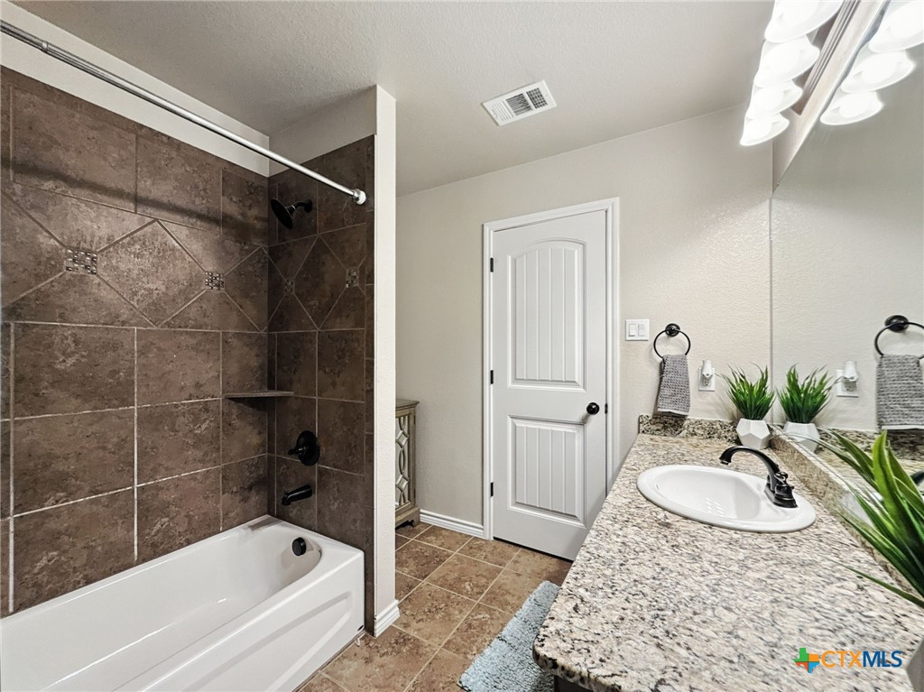 2701 Settlement Road Copperas Cove, TX 76522 - Photo 8 of 18 a bathroom with a granite countertop sink and a bathtub