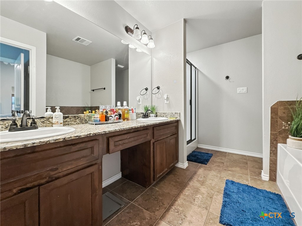 2701 Settlement Road Copperas Cove, TX 76522 - Photo 9 of 18 a spacious bathroom with a granite countertop sink and a mirror