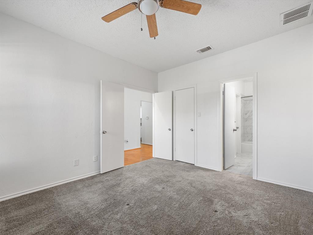 5310 Keller Springs Road, Unit 332 Dallas, TX 75248 - Photo 15 of 39 Unfurnished bedroom with a textured ceiling, carpet flooring, a ceiling fan, a closet, and ensuite bath