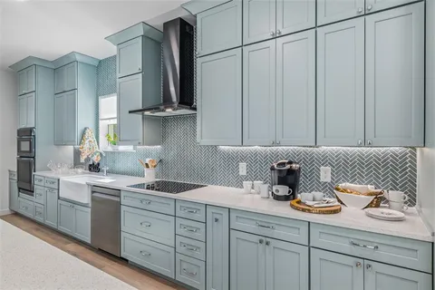 a kitchen with stainless steel appliances a sink a stove and cabinets
