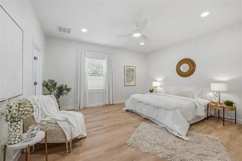a bedroom with a bed and painting on the wall