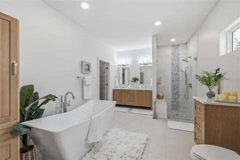 a bathroom with a tub sink and mirror