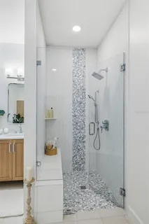 a bathroom with a shower a sink and a mirror