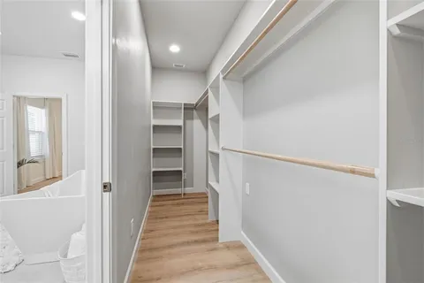 a view of a hallway with wooden floor and entryway
