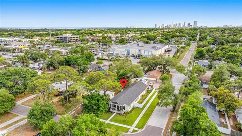 an aerial view of residential houses with outdoor space and trees