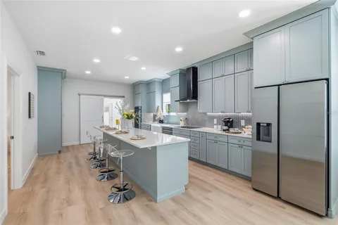 a kitchen with kitchen island a white cabinets and refrigerator