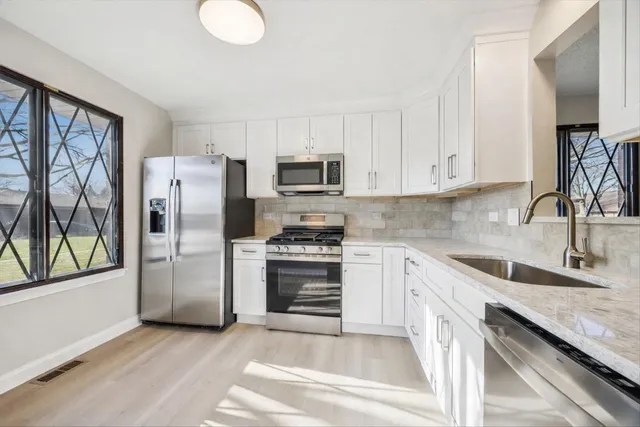 a kitchen with stainless steel appliances granite countertop a stove a sink and a microwave