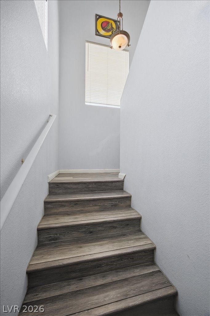 10550 West Alexander Road, Unit 2164 Las Vegas, NV 89129 - Photo 26 of 27 Ascend to the next level on these elegant wood-planked stairs, illuminated by natural light from a well-placed window.