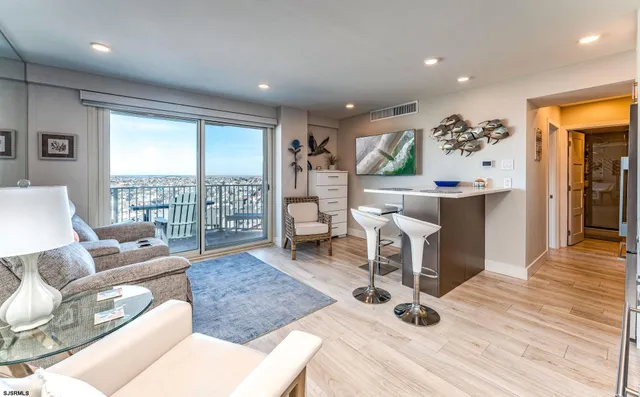 a living room with furniture large window and wooden floor