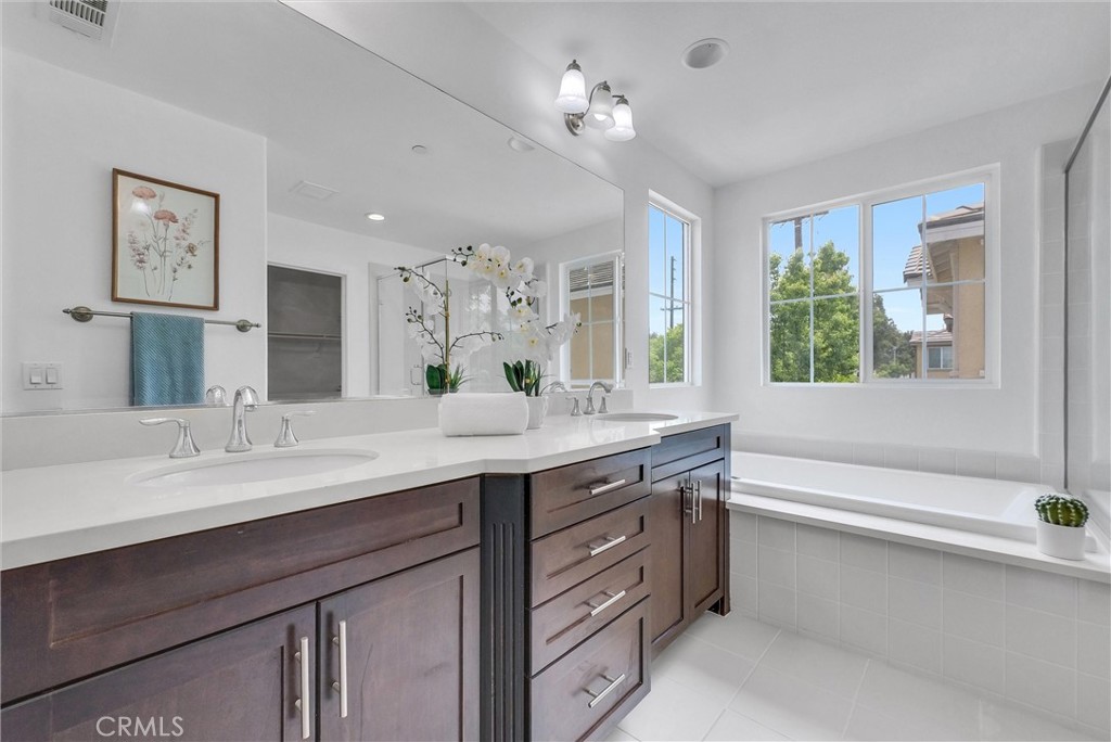 719 Huron Place Claremont, CA 91711 - Photo 23 of 37 a bathroom with a granite countertop sink a large mirror a bathtub and window