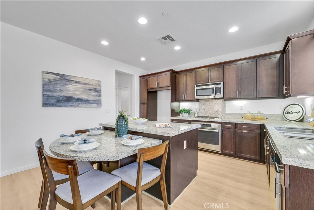 719 Huron Place Claremont, CA 91711 - Photo 6 of 37 a open kitchen with stainless steel appliances granite countertop a stove a sink a dining table and chairs