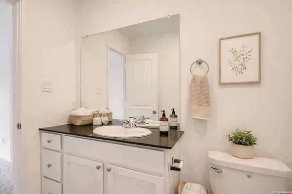 a bathroom with a toilet sink and mirror