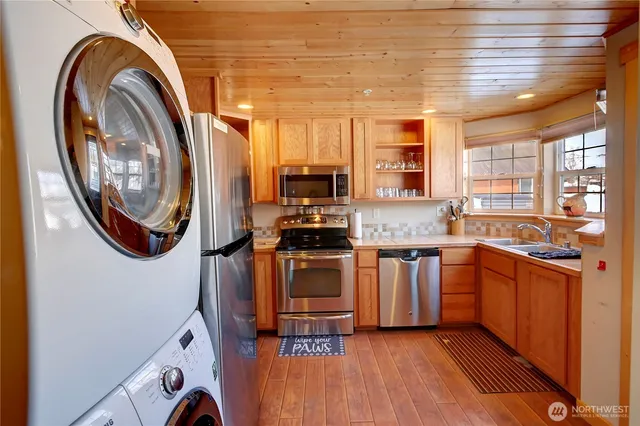 a kitchen with stainless steel appliances granite countertop a stove a sink and a microwave