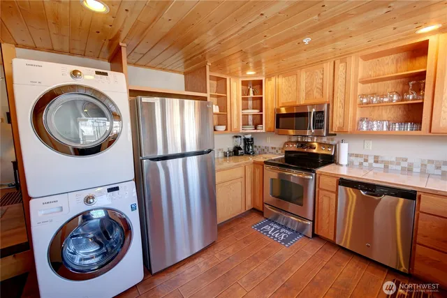 a kitchen with stainless steel appliances granite countertop a refrigerator a stove and a sink