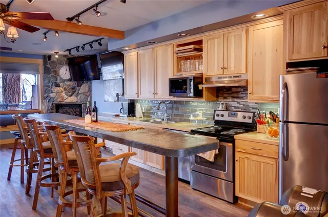 a kitchen with stainless steel appliances a stove a sink refrigerator and a microwave