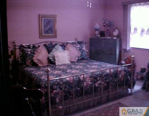 199 Evergreen Road, Unit 12A Edison, NJ 08837 - Photo 4 of 7 a bed sitting in a bedroom next to a window