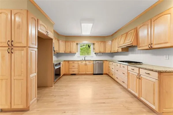 a kitchen with stainless steel appliances granite countertop a stove a sink and a refrigerator