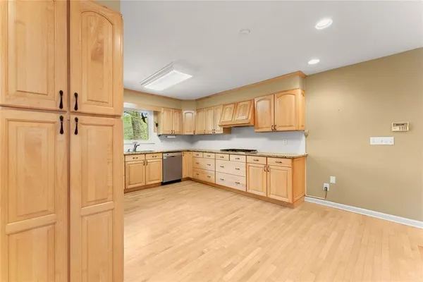 a kitchen with stainless steel appliances granite countertop a sink refrigerator and cabinets