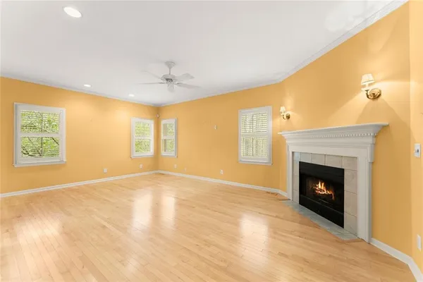 a view of an empty room with a window and a fireplace