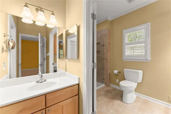 a bathroom with a sink a toilet and a window