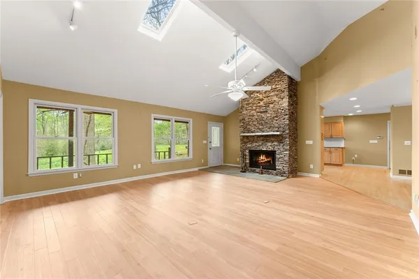 a view of an empty room with window and fire place