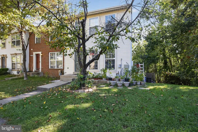 a front view of a house with a yard and tree