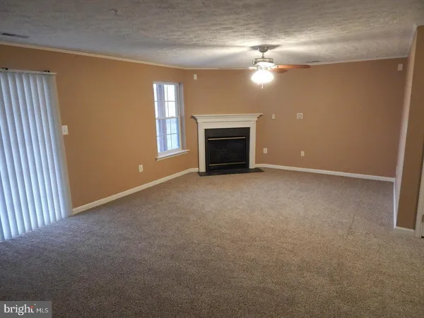 a view of an empty room with a fireplace and a window