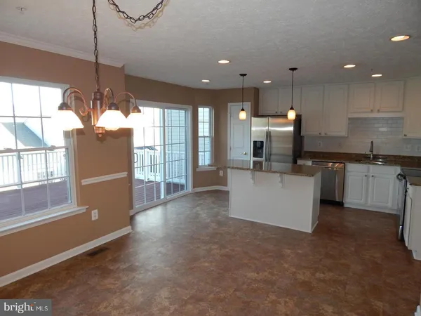 a view of a kitchen with kitchen island a sink wooden floor and a counter top space