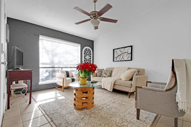 a living room with furniture a flat screen tv and a large window