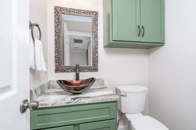 a bathroom with a toilet sink and mirror