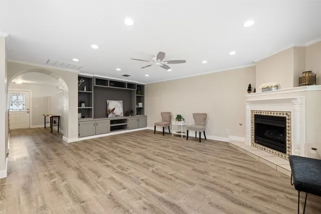 a view of an empty room with kitchen and fireplace