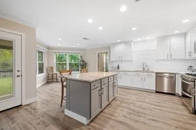 a kitchen with a stove window and cabinets
