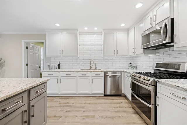 a kitchen with stainless steel appliances granite countertop a sink and stove top oven
