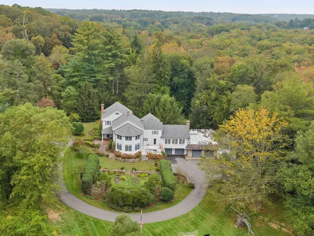 an aerial view of residential houses with outdoor space and trees