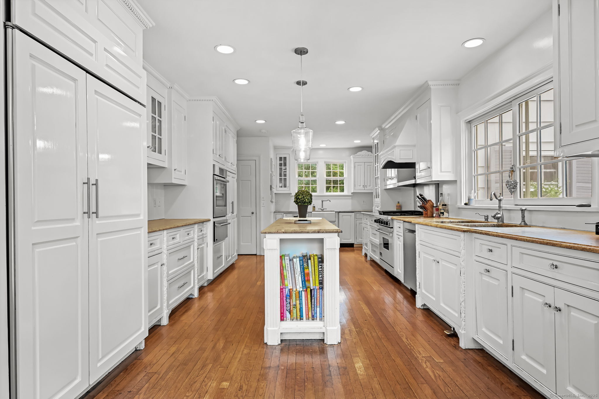 330 Ridgefield Road Wilton, CT 06897 - Photo 12 of 40 a large kitchen with kitchen island wooden floors white cabinets and stainless steel appliances