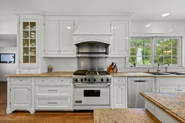 a kitchen with granite countertop a stove sink and cabinets