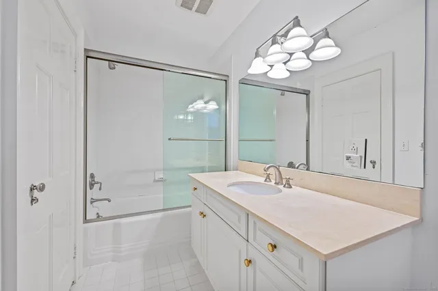 a bathroom with a sink a mirror and a shower