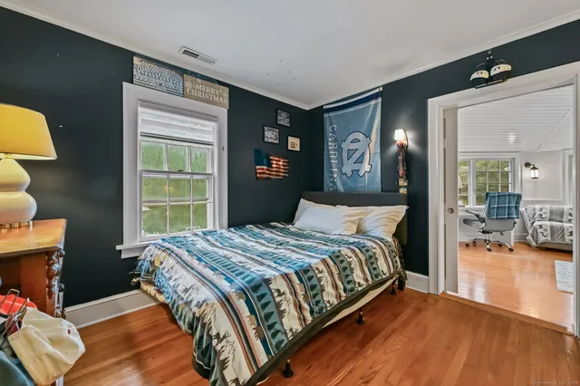 a bedroom with a bed and wooden floor