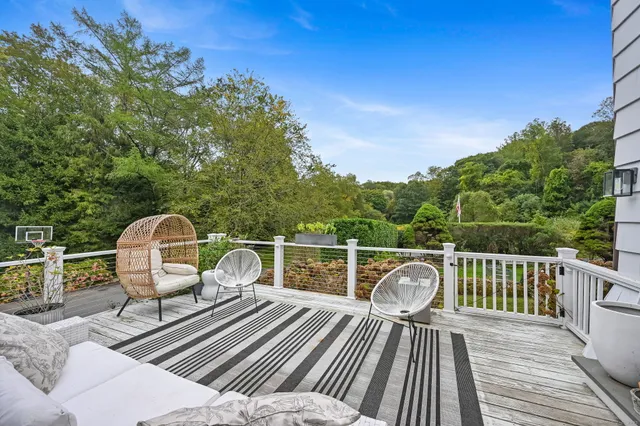 a balcony with wooden floor table and chairs