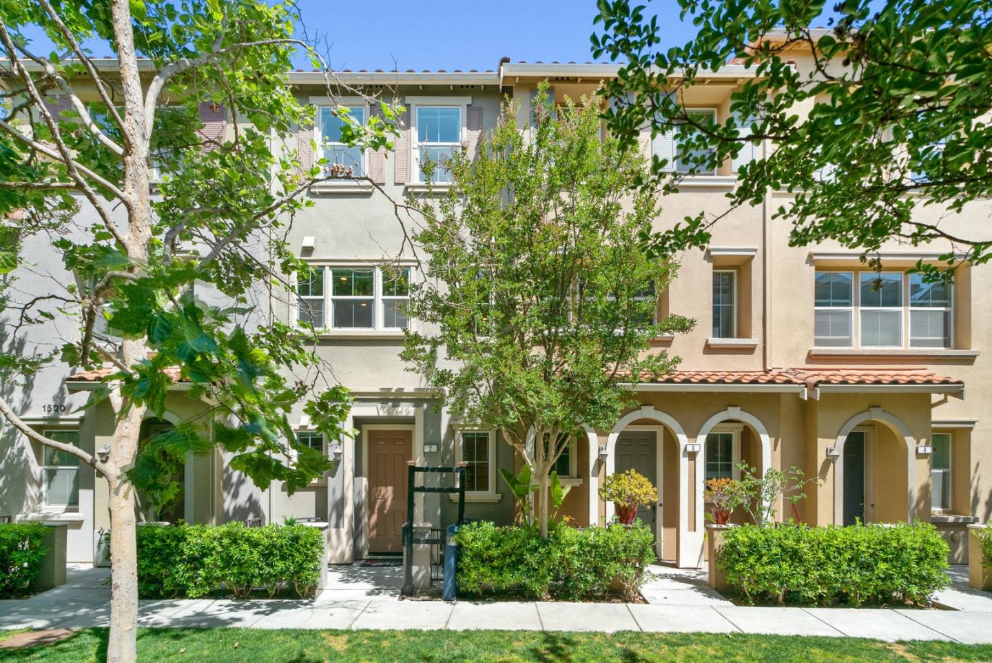 front view of a brick house with a yard