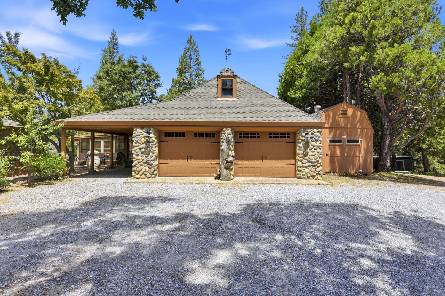 7201 Happy Valley Road Somerset, CA 95684 - Photo 60 of 75 Two-car garage with stone pillars, twin carriage-style doors, and an attached covered carport
