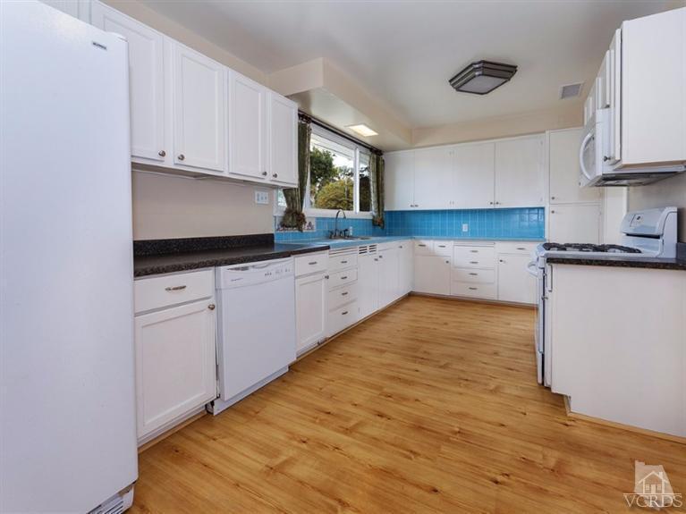 2542 Poli Street Ventura, CA 93003 - Photo 3 of 14 a kitchen with granite countertop white cabinets and wooden floor